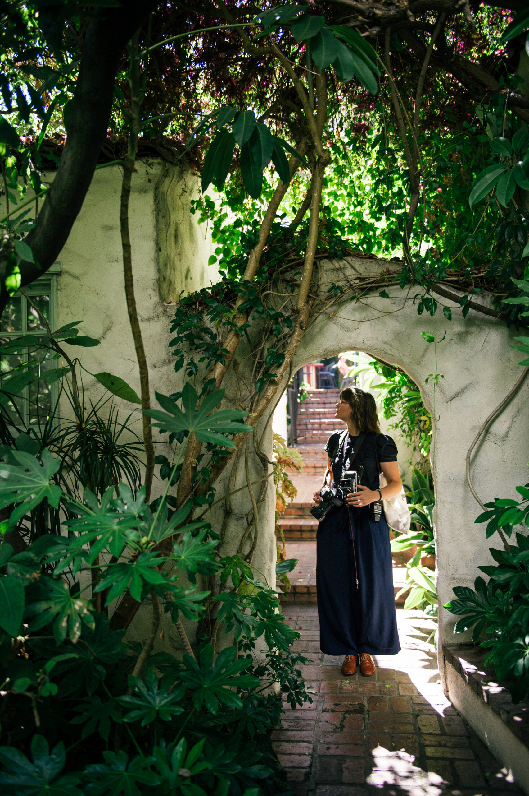 photographer Ivy Reynolds garden stone archway cameras tropical foliage natural light portrait