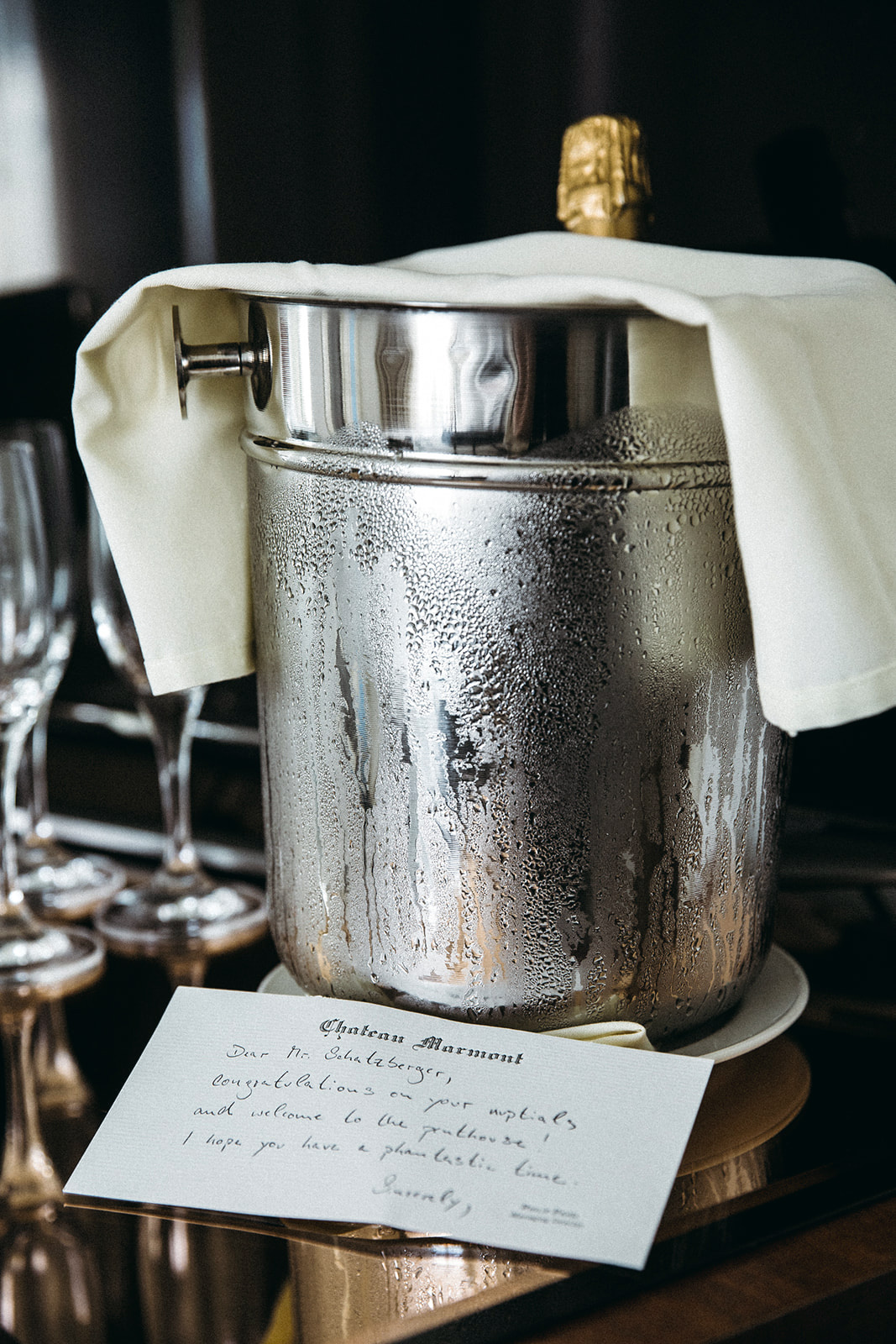 Silver champagne bucket with white linen and handwritten note, Chateau Marmont luxury event detail photography