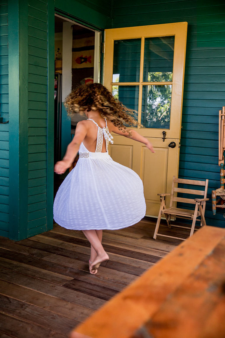 Child standing in doorway with warm golden light, lifestyle editorial photography