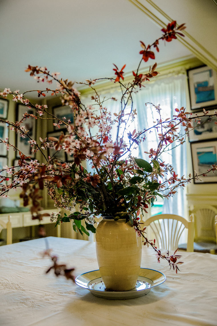 Wild floral arrangement in ceramic vase on table in eclectic interior, lifestyle photography