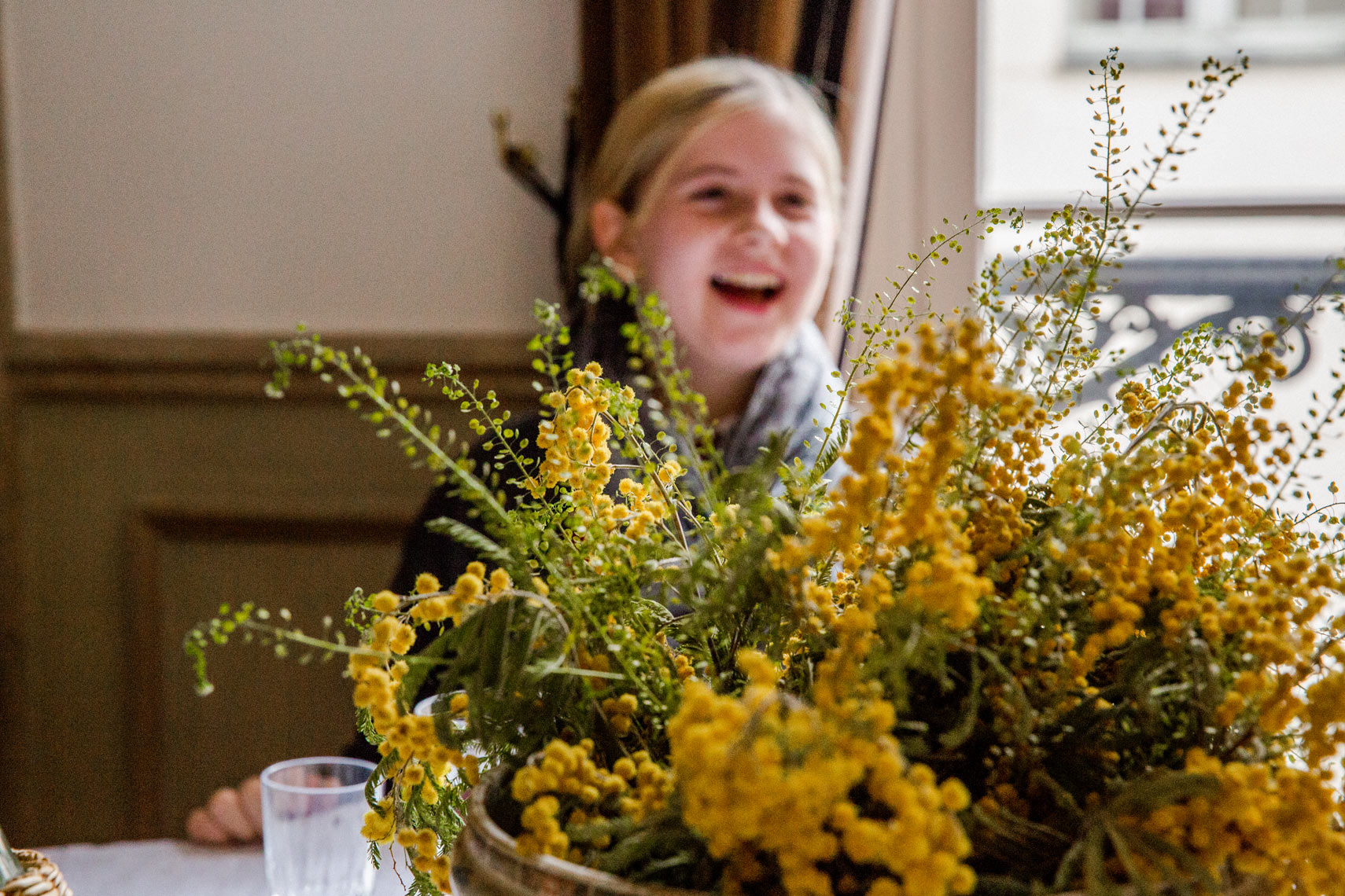 girl laughing yellow mimosa floral arrangement Paris candid lifestyle editorial photography