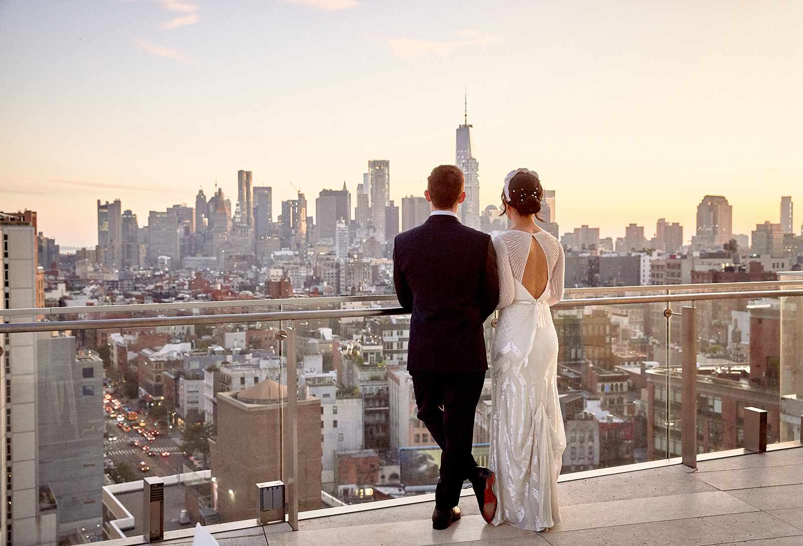 Couple on New York City rooftop at sunset with Empire State Building skyline, luxury wedding photography