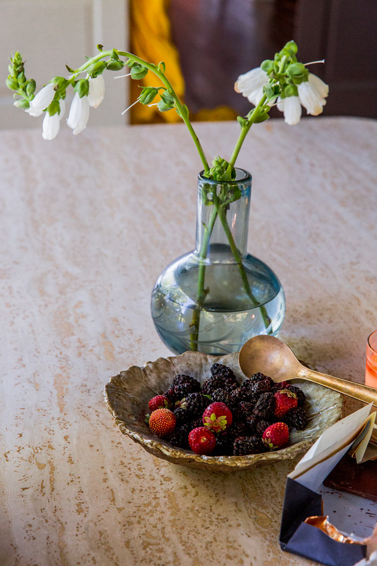 White flowers in glass vase with fruit bowl, clean lifestyle still life photography